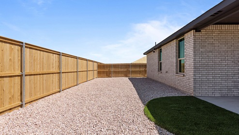 Spacious backyard privately fenced in with modern turf and stone landscape