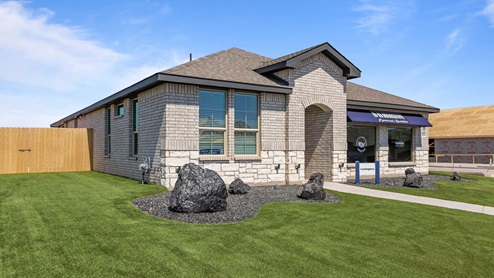 Exterior side view of single-family one-story timeless brick home with stone accents