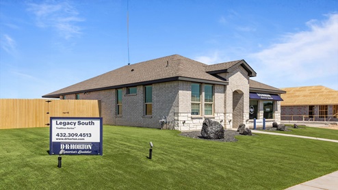 Corner view of Legacy South community model home with clean turf front lawn