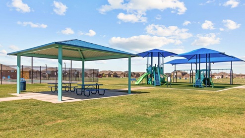 Community covered playground areas with different size play structures and picnic area