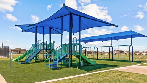 Covered playground area with two play structures and swings