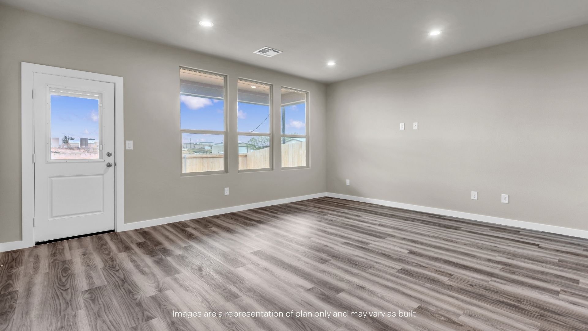 Open-concept living area with wood-look flooring, recessed lighting, and convenient access to the staircase and kitchen