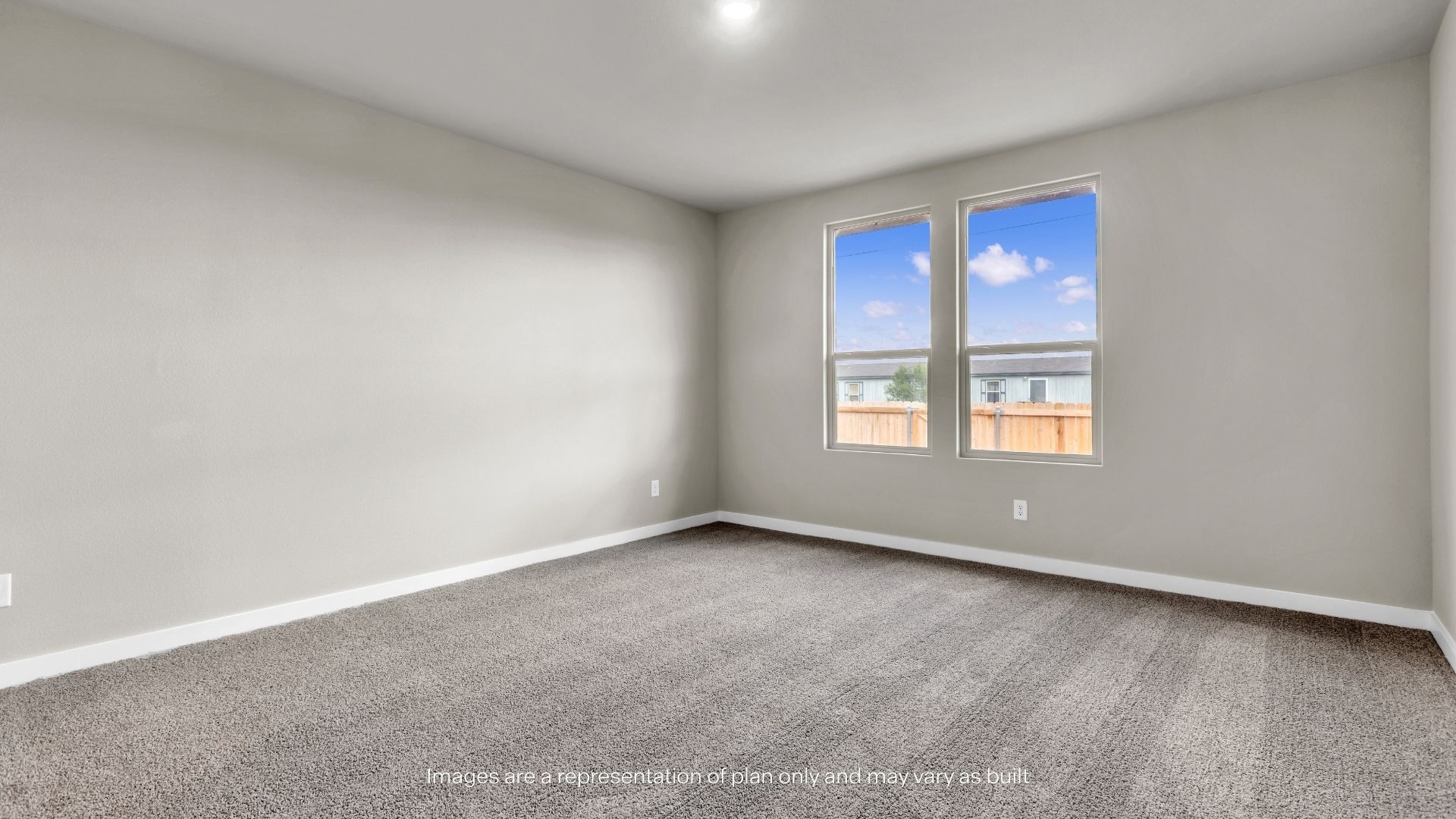Spacious primary bedroom featuring plush carpeting, neutral finishes, and large windows that provide abundant natural light.