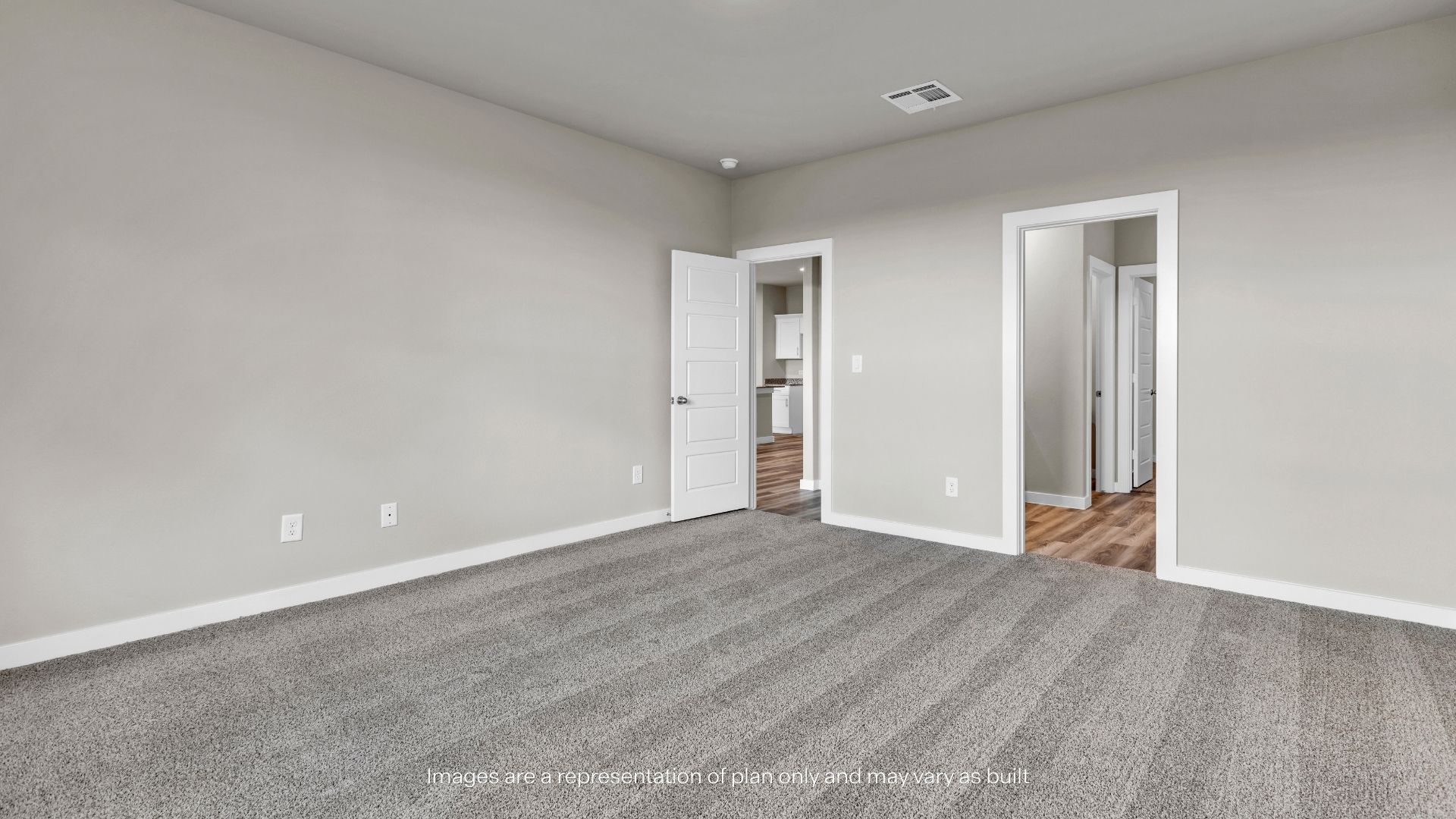 Expansive primary suite with soft carpeting, airy dimensions, and direct access to the adjoining living spaces.