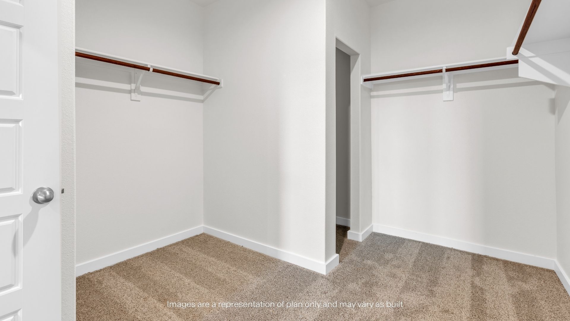 Large walk-in closet with dual hanging rods, ample storage space, and plush carpeting.