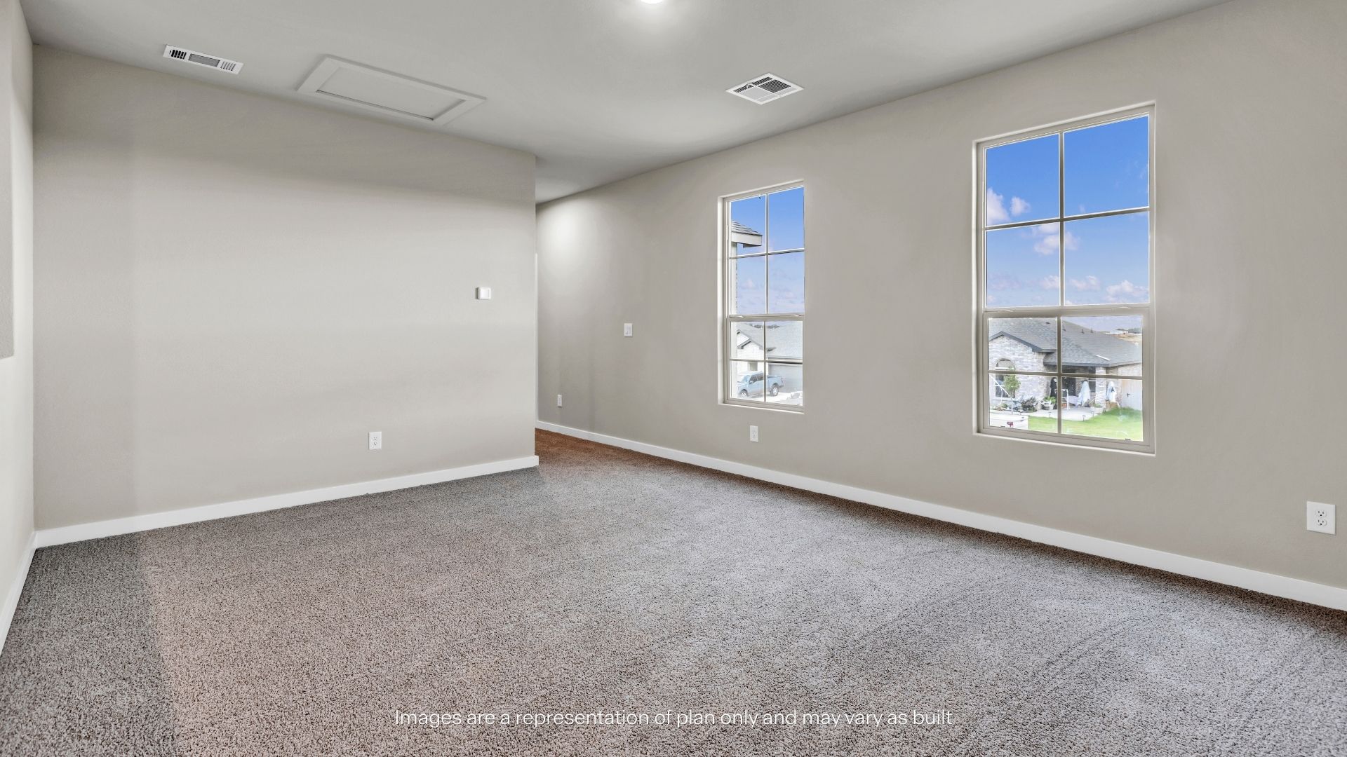 Expansive upstairs game room with plush carpeting, abundant natural light, and flexible space for entertainment or relaxation.