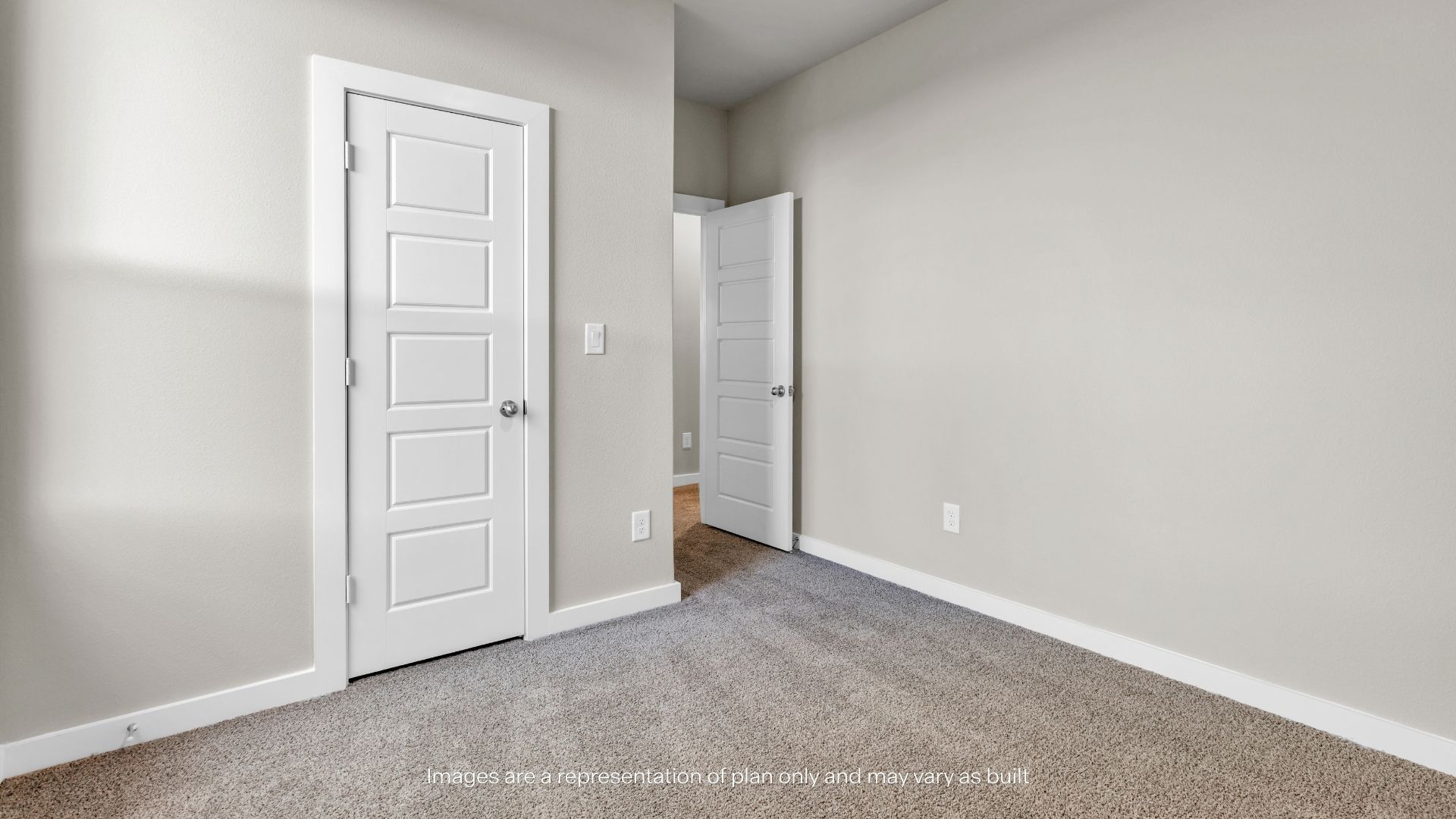 Comfortable secondary bedroom with plush carpeting, neutral paint tones, and convenient access to the hallway.