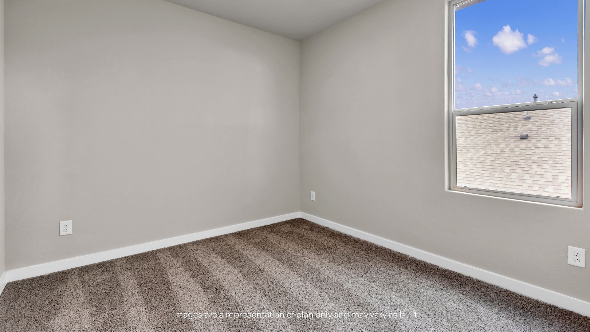 Cozy secondary bedroom featuring a large window, soft carpeting, and abundant natural light.