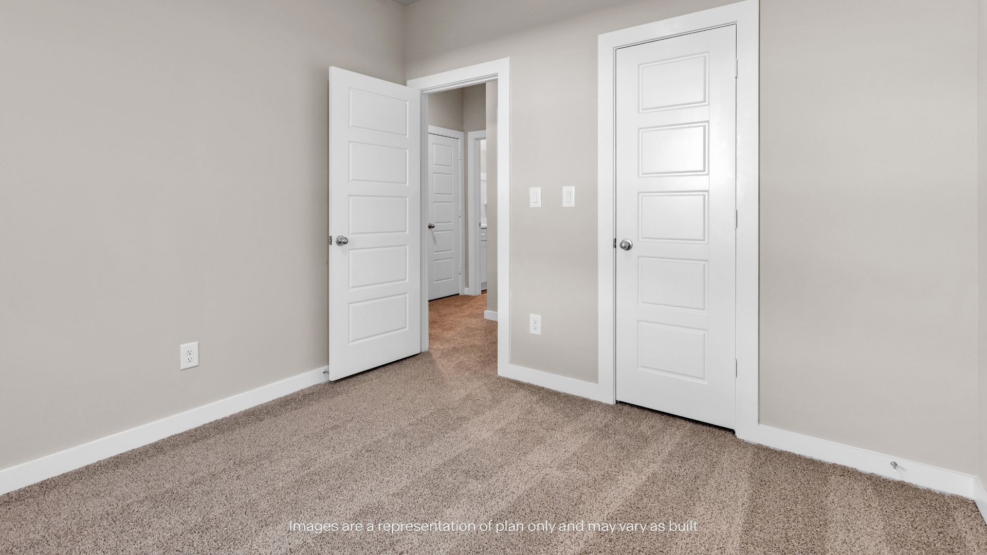 Bright secondary bedroom with neutral finishes, plush carpeting, and a functional layout for guests or family members.
