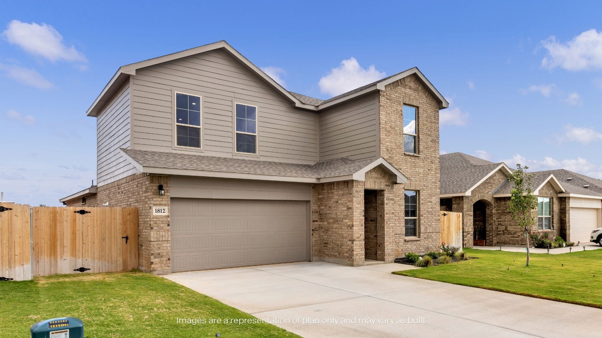 Wide exterior view showcasing the spacious driveway, attached two-car garage, and attractive architectural details.