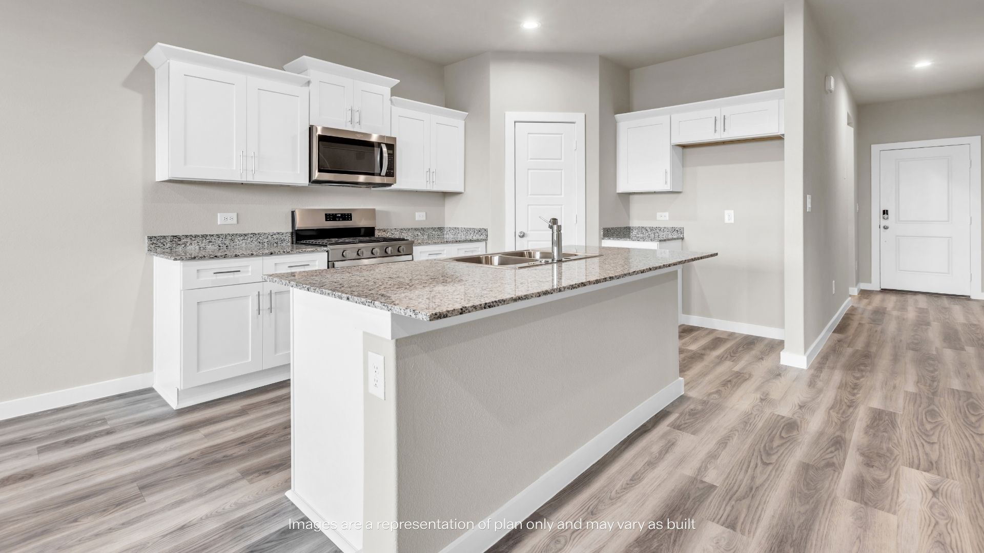 Modern open-concept kitchen featuring a large granite island, stainless steel appliances, white cabinetry, and views into the dining area.