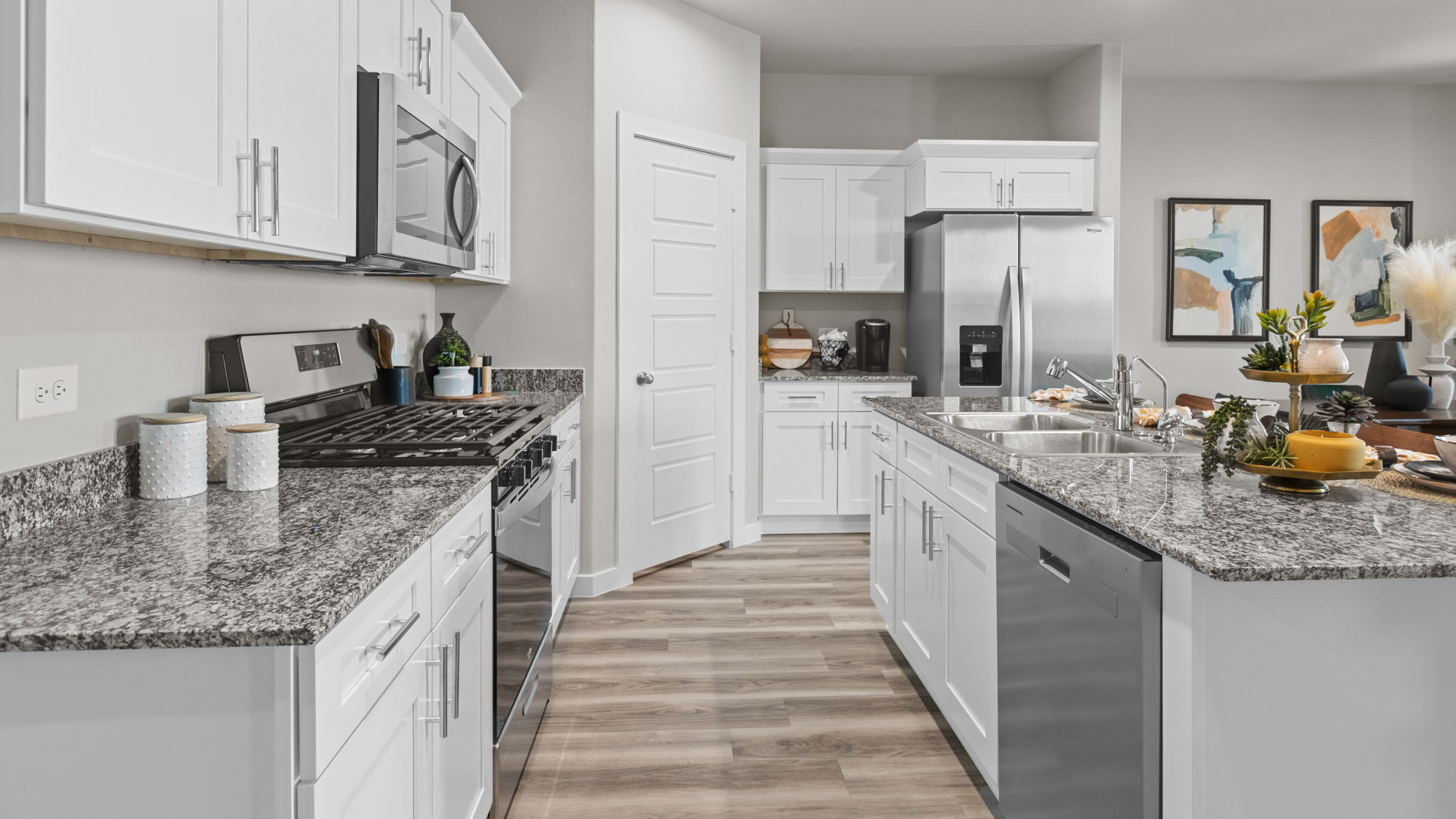 Open concept kitchen with stainless steel appliances, shaker style cabinets, and elevated finishes