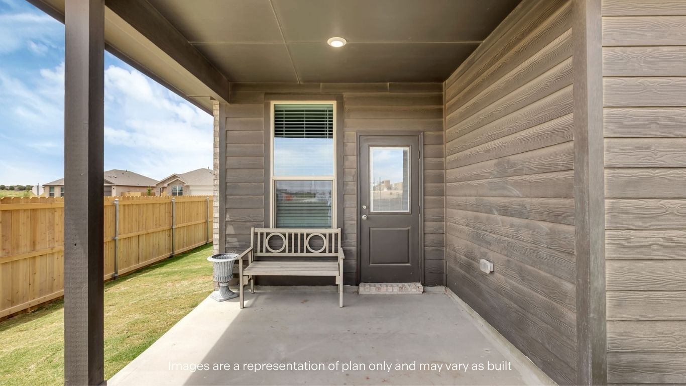 Covered back patio area overlooking spacious backyard