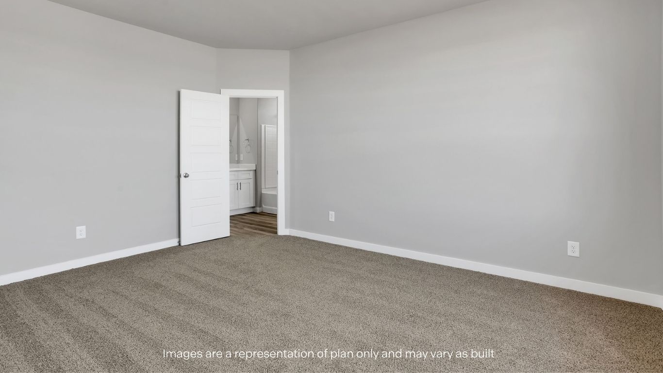 Another spacious bedroom featuring neutral tones and easy access to an adjoining bathroom.