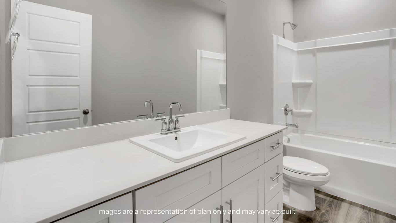 A bedroom with a large window providing natural light and neutral interior finishes.