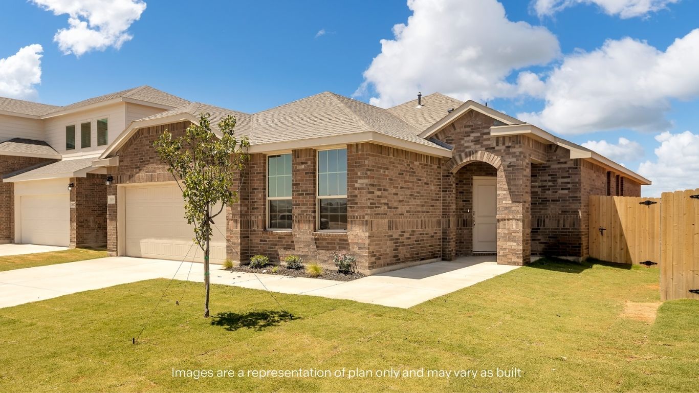 A side-angle view of the brick home highlighting the covered entryway and landscaped yard.
