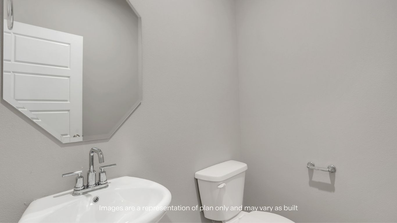 A compact half bathroom featuring a pedestal sink, mirror, and toilet with clean, modern fixtures.