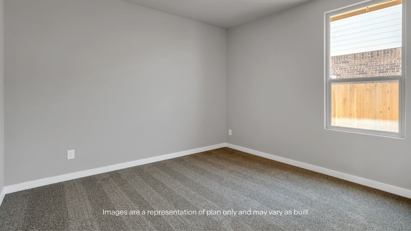 A spacious bedroom with plush carpeting and a large window bringing in natural light.