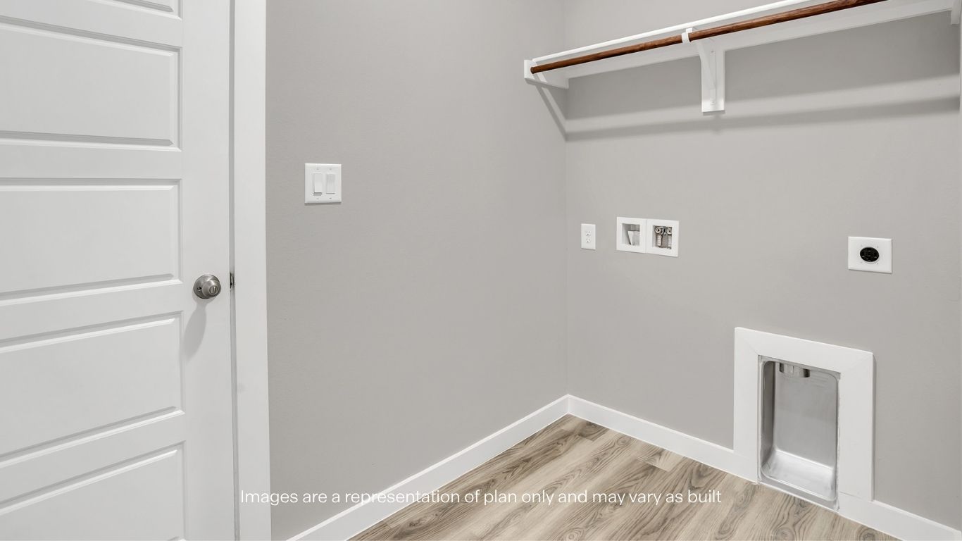A functional laundry room with washer and dryer hookups, shelving, and durable flooring.
