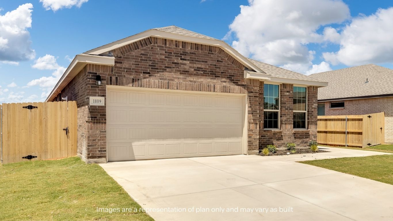 A front-facing view of the home with a spacious driveway and fenced backyard.