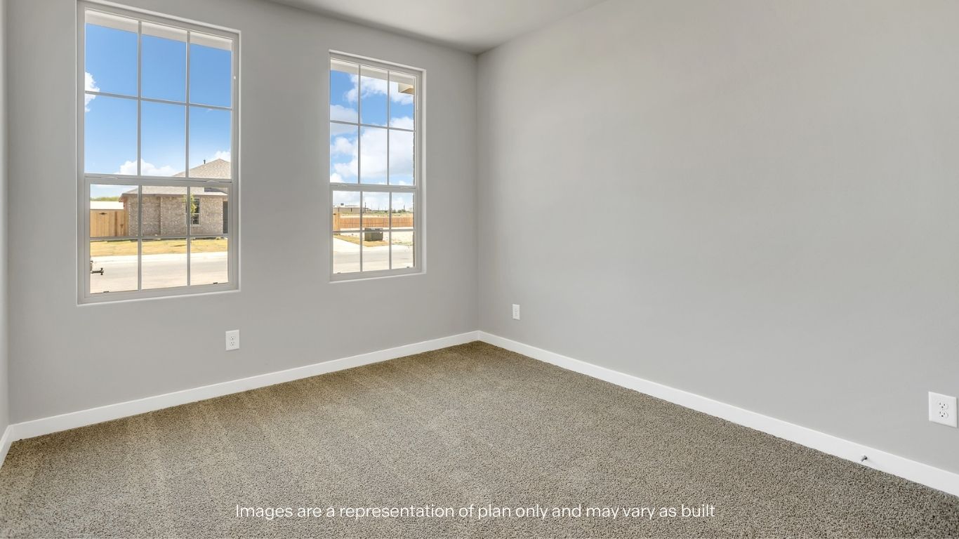 A bright, empty bedroom with large windows allowing in plenty of natural light.