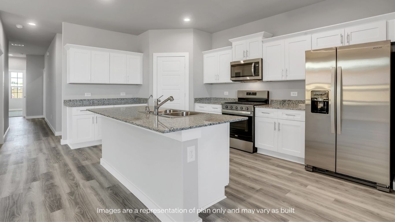 A modern kitchen featuring white cabinets, stainless steel appliances, and a large island.