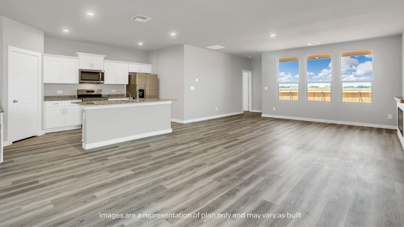 A spacious living and kitchen area filled with natural light from multiple windows.