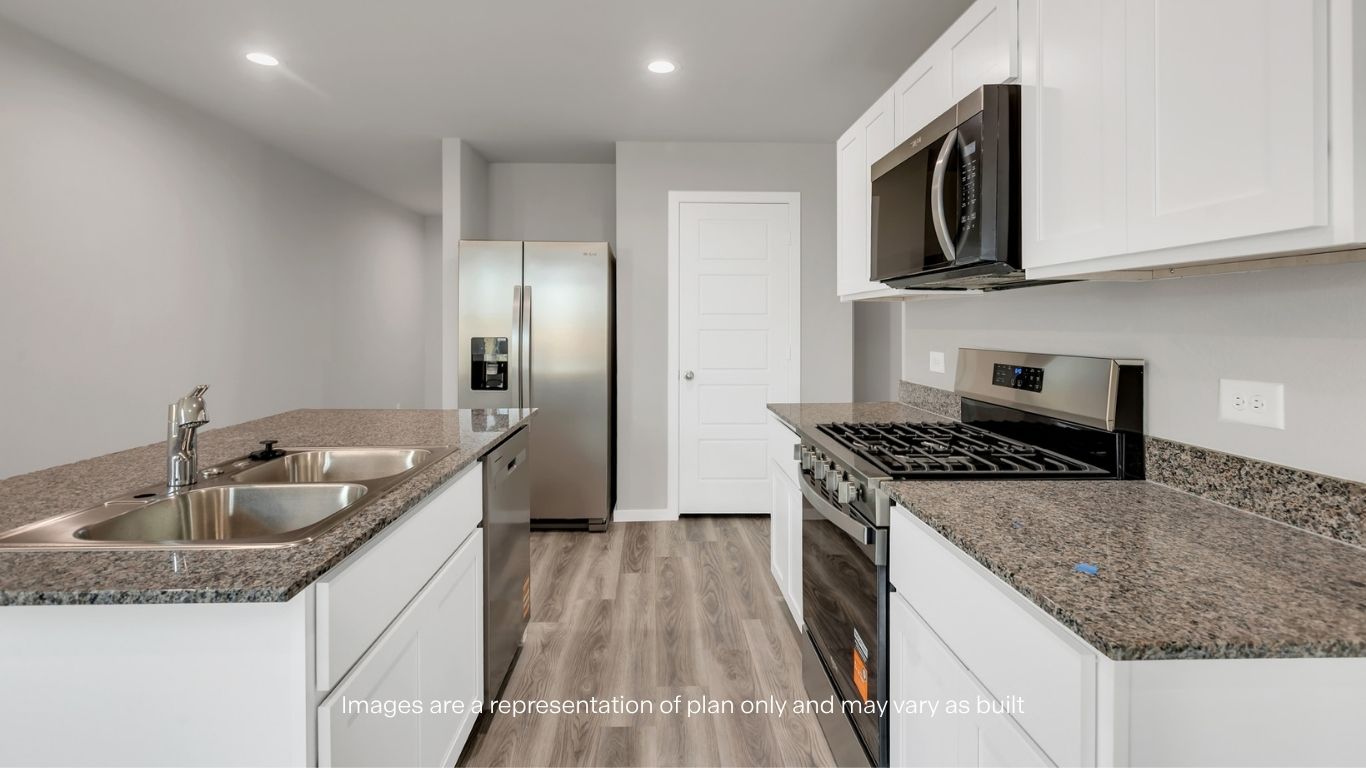 Modern kitchen featuring granite countertops, white cabinetry, stainless steel appliances, and a functional island.