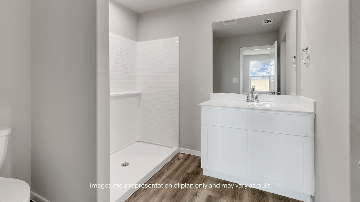 Clean and modern primary bath with a spacious shower and vanity.
