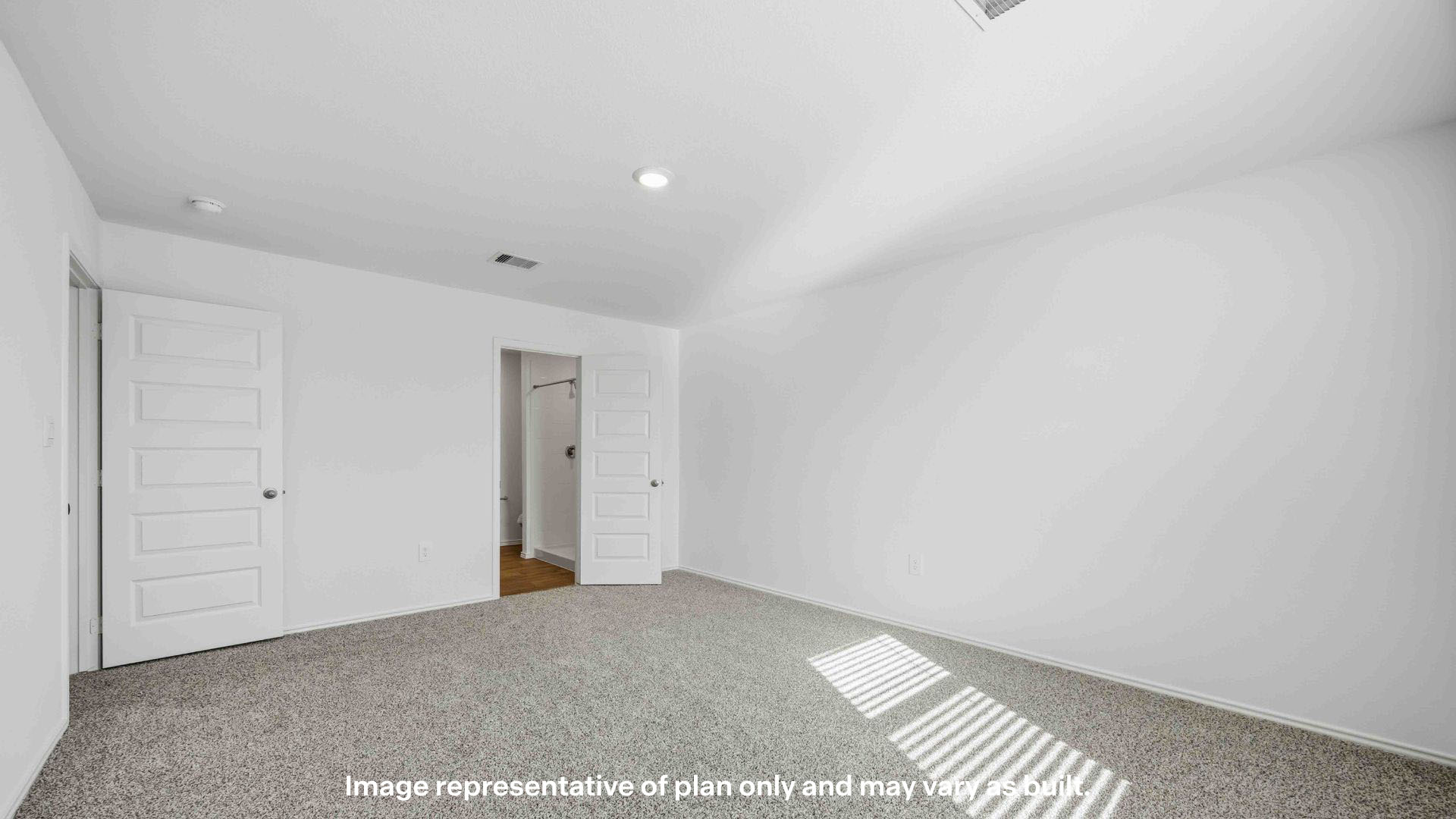 Primary bedroom with plush carpet floors and light allowing window