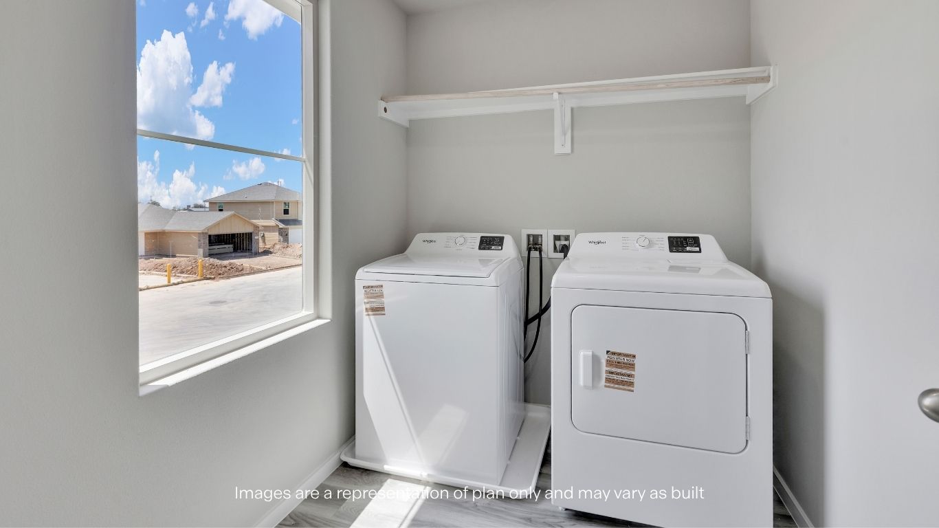 Conveniently located upstairs near all bedrooms, the laundry room offers dedicated washer and dryer space, additional storage shelving, and natural light from a large window.