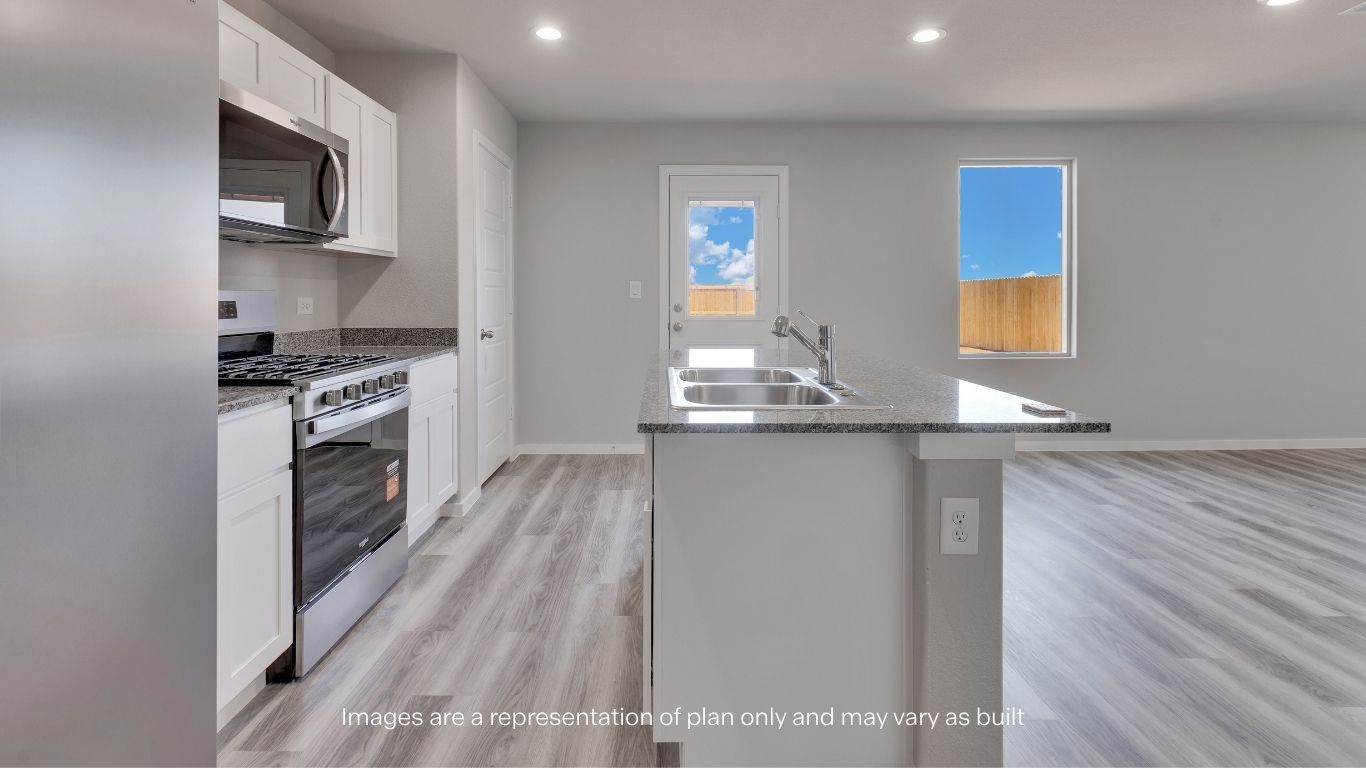 The kitchen opens seamlessly into the dining and living spaces, featuring granite countertops, shaker-style cabinetry, and stainless steel appliances.