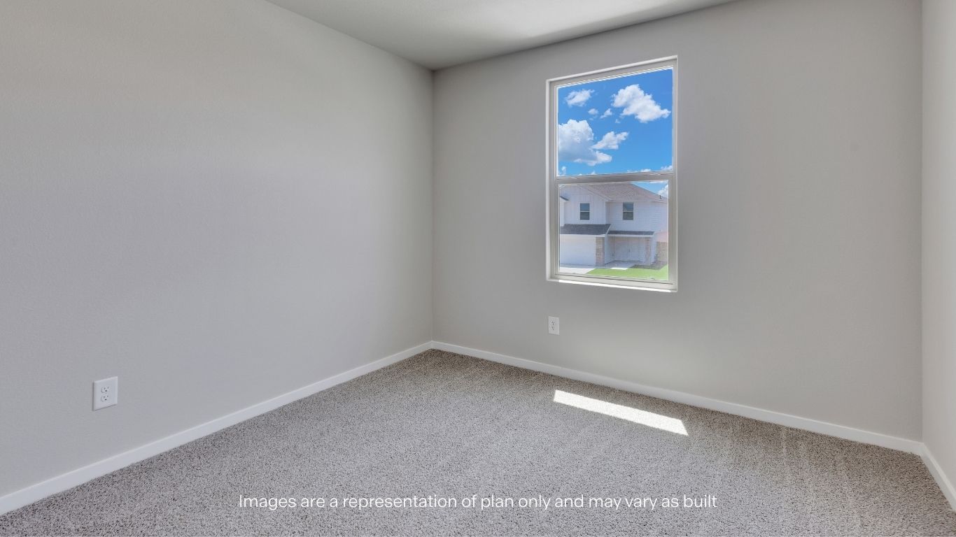 This versatile secondary bedroom features plush carpet flooring, neutral finishes, and a large window that fills the space with natural light, making it ideal for a bedroom, home office, or flex space.