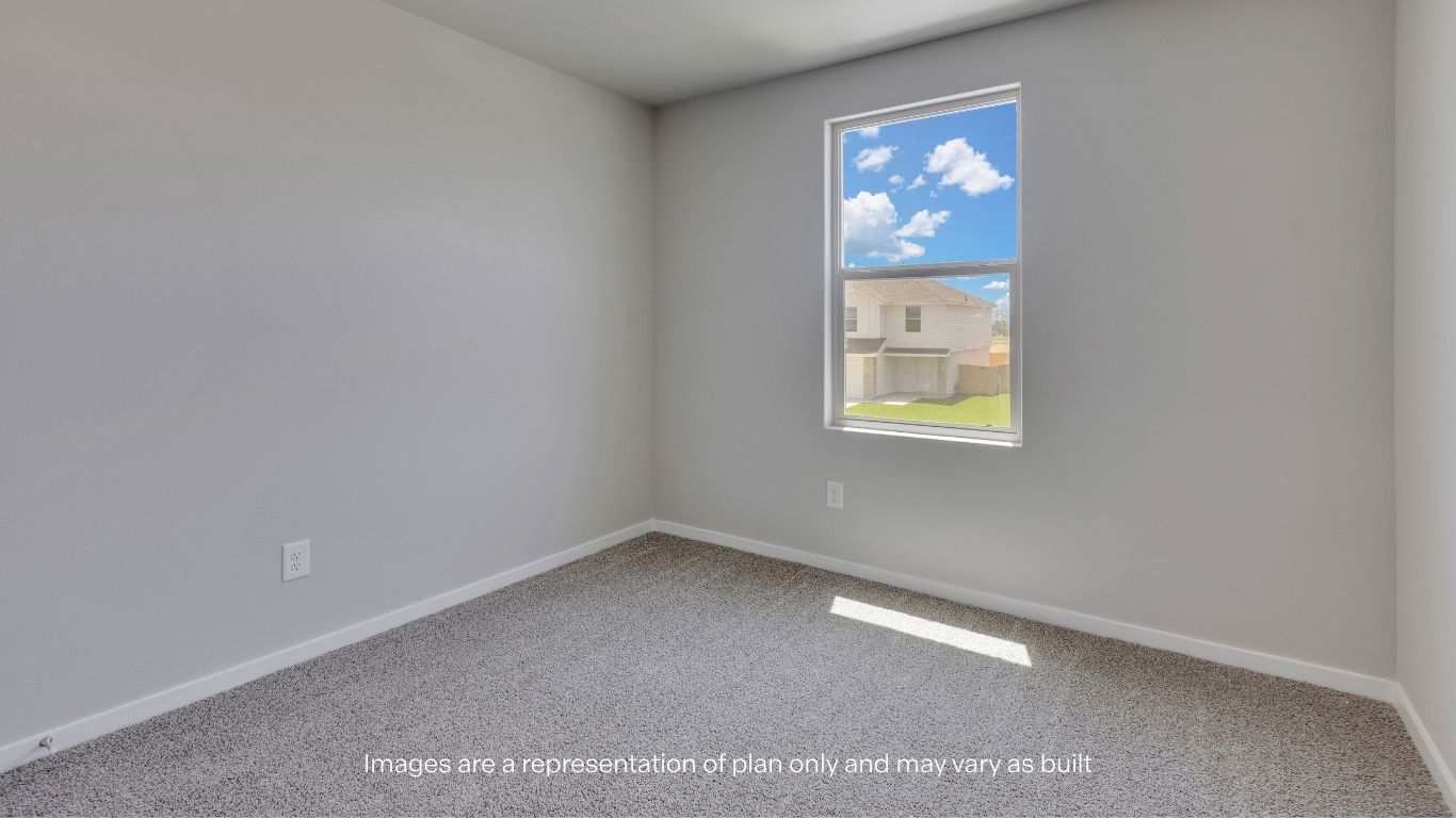 Bright and inviting, this upstairs guest bedroom offers comfortable living space with soft carpeting, ample wall space for furnishings, and a large window overlooking the community.