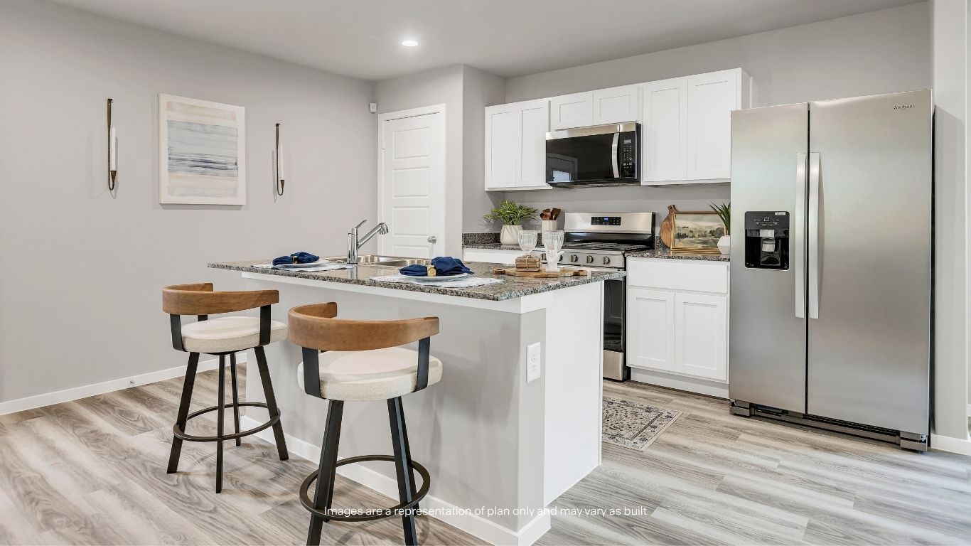 The kitchen features granite countertops, shaker-style cabinetry, stainless steel appliances, and a convenient breakfast bar for additional seating.