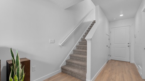 Entry way to townhome with stairs to next level and doors to flex room and bathroom.