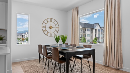 Dining area with 6 person table with two large windows.