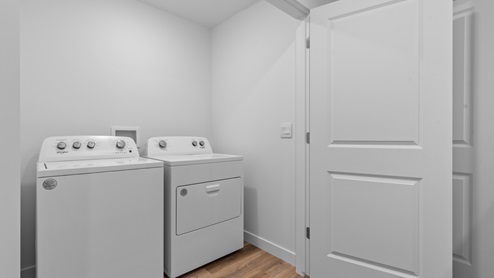 Laundry area with double doors in hallway.