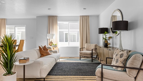 The living room on the main floor boasts a large window and plenty of room for lounging or entertaining in a new townhome in Saratoga Springs Utah.