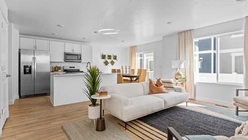 An open concept main floor has your living room, kitchen and dining room all in one large space with a large kitchen island, white shaker cabinets and stainless steel appliances.