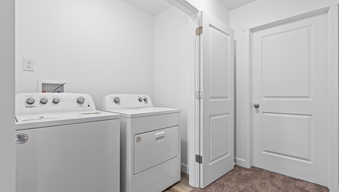 Laundry room with two doors that open into it.