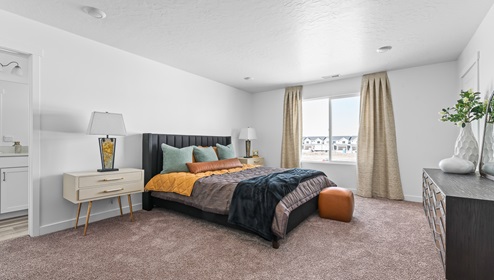 Spacious primary bedroom with a large window.