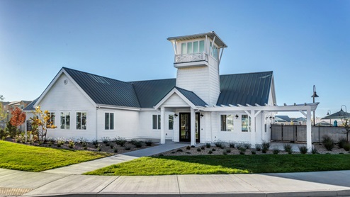 Northshore clubhouse with white siding and a lighthouse style classic look with very attractive landscaping.
