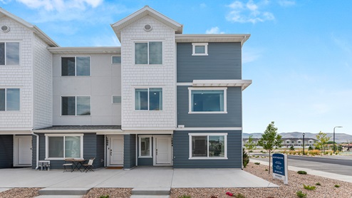 New townhome units in Saratoga Springs Utah with dusty blue and white siding and white trim and covered porches.