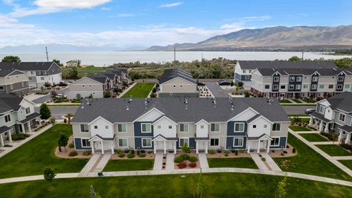 Beautiful aerial photo of the Northshore community by D.R. Horton of townhomes, community monument, clubhouse and pool and surrounding mountains and Utah Lake.