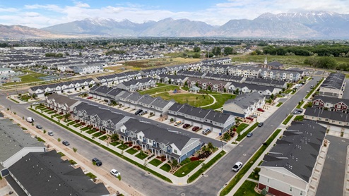 Beautiful aerial photo of the Northshore community by D.R. Horton of townhomes, community monument, clubhouse and pool and surrounding mountains and Utah Lake.