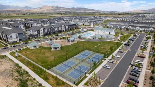 Beautiful aerial photo of the Northshore community by D.R. Horton of townhomes, community monument, clubhouse and pool and surrounding mountains and Utah Lake.