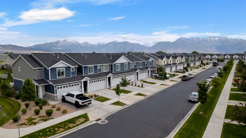 Beautiful aerial photo of the Northshore community by D.R. Horton of townhomes, community monument, clubhouse and pool and surrounding mountains and Utah Lake.