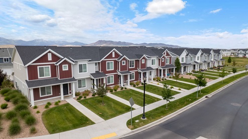 Beautiful aerial photo of the Northshore community by D.R. Horton of townhomes, community monument, clubhouse and pool and surrounding mountains and Utah Lake.