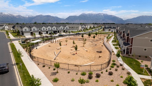 Beautiful aerial photo of the Northshore community by D.R. Horton of townhomes, community monument, clubhouse and pool and surrounding mountains and Utah Lake.